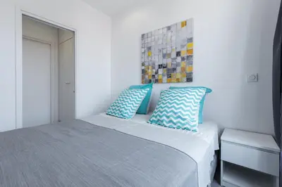 a bedroom with a bed with blue and white pillows at Olma in Nice
