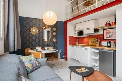 a dining room with a table with chairs and a mirror at Nice-Duplex-Plage-Parking-Cimatisation in Nice