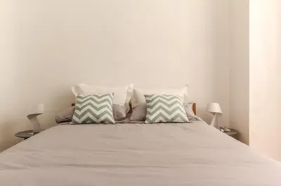 a bed with white sheets and pillows in a bedroom at MY CASA - VEILLON - 2 bedrooms - City Center in Nice