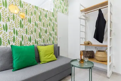a living room with a gray couch and a green and white wall at Casa Madere- Idéal Couples - Central & cosy -Train station - Tram & Supermarkets-Balcony- Washing-machine-AC in Nice
