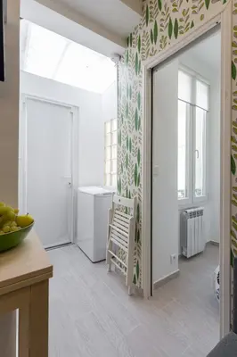 a kitchen with a door leading into a room with a table at Casa Madere- Idéal Couples - Central & cosy -Train station - Tram & Supermarkets-Balcony- Washing-machine-AC in Nice