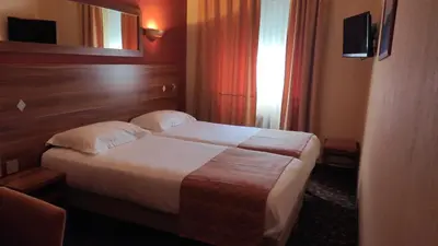 a hotel room with a bed and a television at Residence Share Inn in Nice
