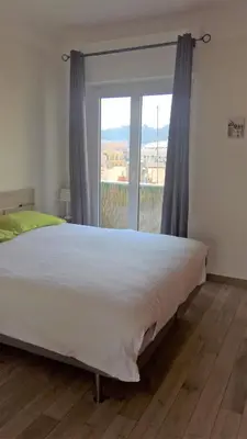 a large bed in a room with a large window at Val Roya Terrasse in Nice
