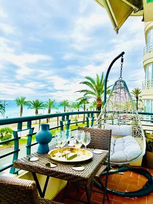 a table and chairs on a balcony with a view of the ocean at Endless Stunning Mediterranean Sea Views Promenade Des Anglais in Nice