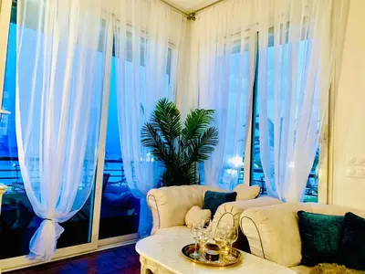 a living room with blue curtains and a couch at Endless Stunning Mediterranean Sea Views Promenade Des Anglais in Nice