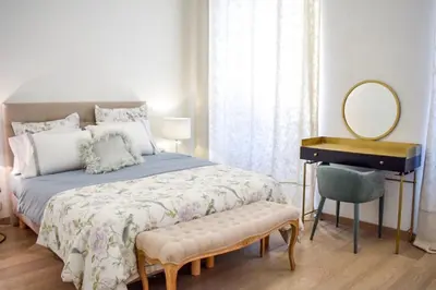 a bedroom with a bed with a mirror and a dressing table at Résidence Barla in Nice