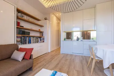 a kitchen and living room with a couch and a table at GRAND HÔTEL Golden Square 3 min to Beach Green Corridor View AC in Nice