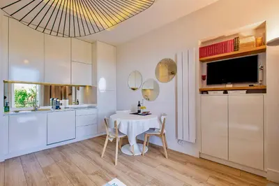 a kitchen with a white table and chairs and a sink at GRAND HÔTEL Golden Square 3 min to Beach Green Corridor View AC in Nice