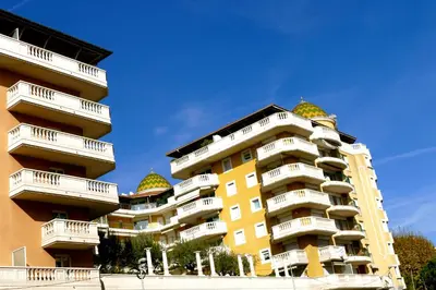 a yellow apartment building with domes on its balconies at Studios Nice French Riviera in Nice