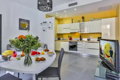 a kitchen and dining room with a table and a tv at MY CASA - FRANCE 82 D - 2 rooms - Terrace - 1 min to the Sea in Nice