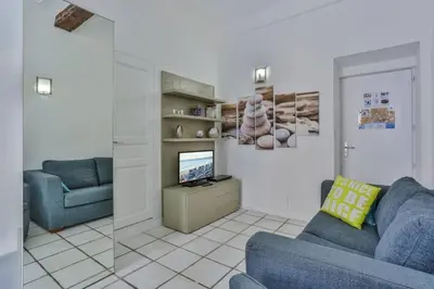 a living room with a blue couch and a television at MY CASA - MARI 117 - City Center in Nice