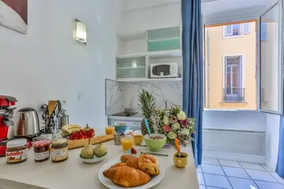 a kitchen counter with plates of food on it at MY CASA - MARI 117 - City Center in Nice