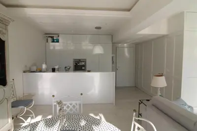 a living room with a table and a kitchen at La Reale in Villefranche-sur-Mer