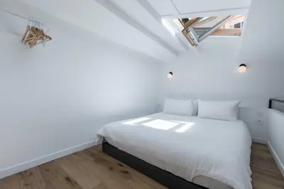 a bedroom with a white bed in a white room at Malonat Duplex - Old Town in Nice