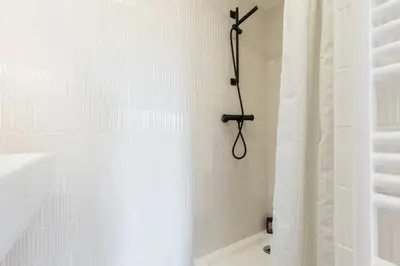 a white bathroom with a shower with a shower curtain at Malonat Duplex - Old Town in Nice