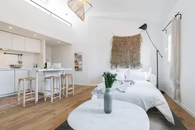 a bedroom with a bed and a table with a vase on it at Malonat Duplex - Old Town in Nice