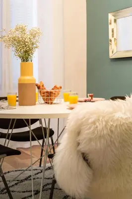 a white dog laying on the floor next to a table at Moulin -Old Town in Nice