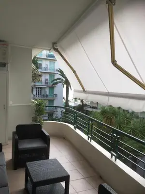 a balcony with chairs and tables on a building at Nice Beach - Promenade Des Anglais in Nice