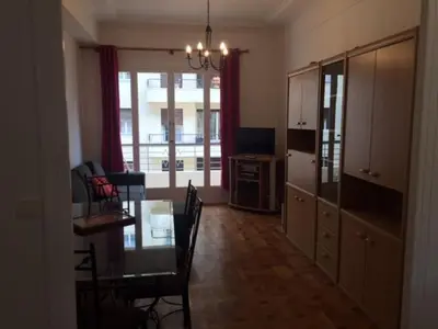a living room with a dining table and a kitchen at Le Palais Martine in Nice