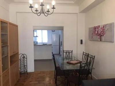 a dining room and kitchen with a glass table and chairs at Le Palais Martine in Nice