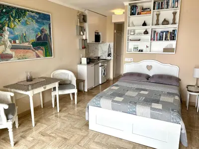 a bedroom with a bed and a table and chairs at Studio Leopolda in Villefranche-sur-Mer