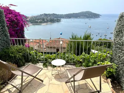 a balcony with a table and chairs and a view of the water at Studio Leopolda in Villefranche-sur-Mer