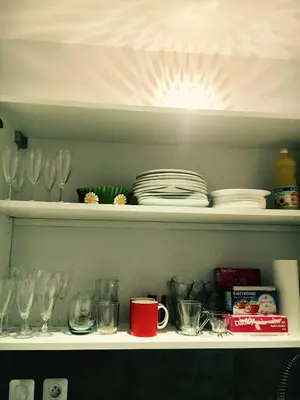a shelf with glasses and plates and dishes on it at Appartment Le Charme du Bourgeois in Nice