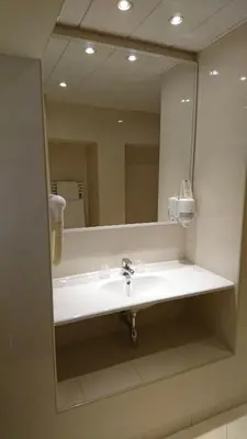 a bathroom with a sink and a large mirror at Residence Club Inn in Nice
