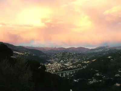 a view of a city from a mountain under a cloudy sky at Les lilas blancs in Villefranche-sur-Mer