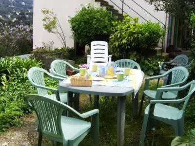 a table and chairs with a table and chairs at Les lilas blancs in Villefranche-sur-Mer