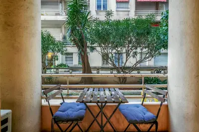 a table on a balcony with a vase of flowers at T2 refait à neuf - Mer & Promenade des Anglais - Negresco in Nice