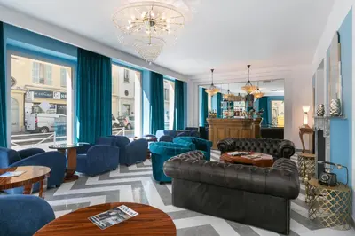 a living room with blue furniture and a chandelier at The Jay Hotel by HappyCulture in Nice
