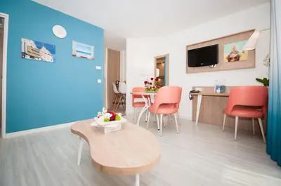a living room with a table and red chairs at Residhome Nice Promenade in Nice
