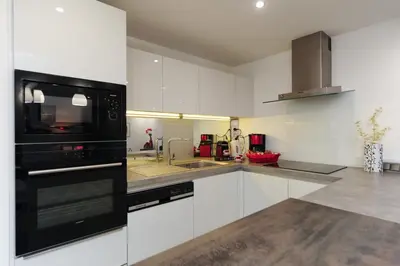 a kitchen with white cabinets and a black microwave at Nice Étoile Grand Suite Five stars Holiday House in Nice