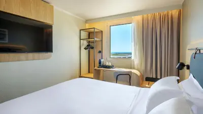 a hotel room with a bed and a window at Campanile PRIME - Nice Airport in Nice