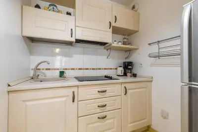 a kitchen with white cabinets and a sink and a refrigerator at Nice 1 Bedroom downtown Carré d'Or with garage in Nice