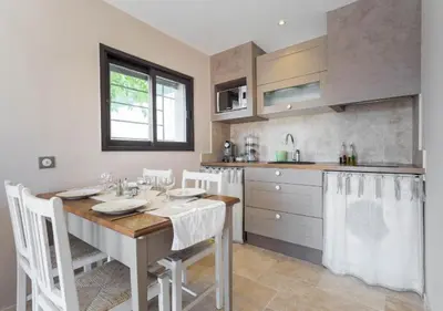 a kitchen with a table with chairs and a sink at La maison de lulu in Nice