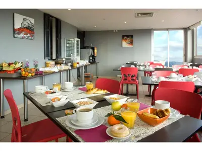 a dining room with a table with food on it at Hôtel Du Baou in La Gaude