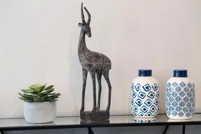 a statue of a giraffe on a table next to vases at Hôtel Relais Acropolis in Nice