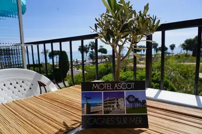a sign in front of a house with a rocking chair at MOTEL ASCOT - Hotel & Appartements in Cagnes-sur-Mer