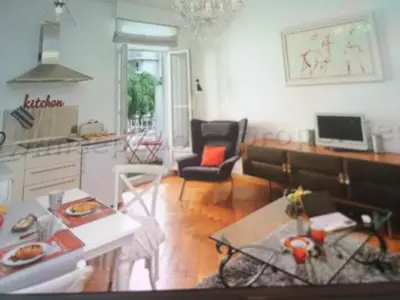 a room with a kitchen and a living room with a table at Carre d or in Nice