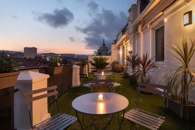 a patio with tables and chairs on a balcony at Hôtel Byakko Nice in Nice