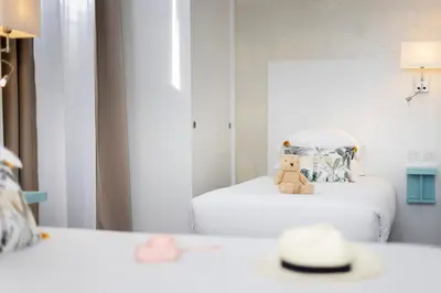 a teddy bear sitting on a chair in a room at Hôtel Byakko Nice in Nice