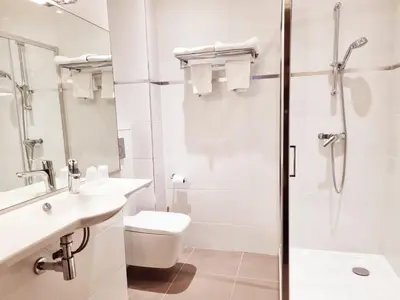 a bathroom with a shower and a toilet and a sink at Hotel Carlton Nice in Nice