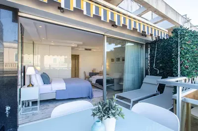 a room with a bed and a table and a television at ROYAL PROMENADE Pool Terrace Sea View Air Conditioning in Nice