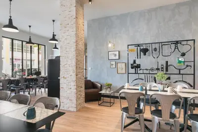 a restaurant with tables and chairs in a room at Hotel So’Co by Happyculture in Nice