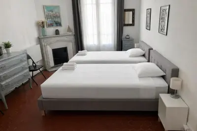 a bedroom with a white bed and a fireplace at L'Écrin Blanc Niçois - Welkeys in Nice