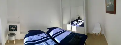 a white room with two beds and a mirror at Apartment on Place Massena in Nice