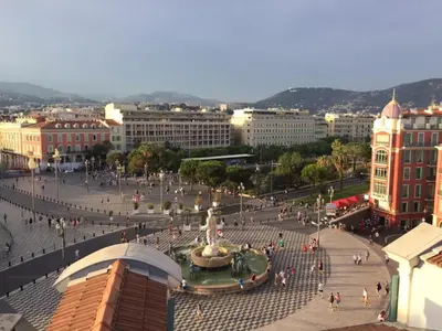 a group of people walking around a plaza in a city at Apartment on Place Massena in Nice