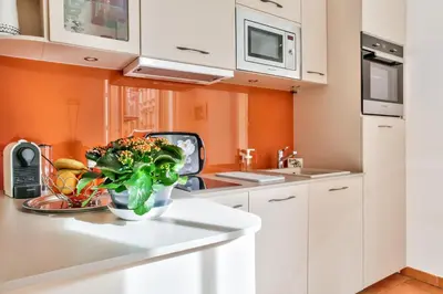a kitchen with white cabinets and a vase of flowers at L'Olivette in Nice